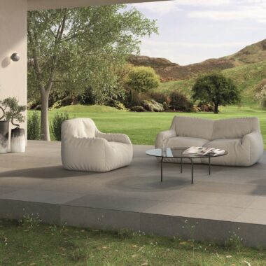 Juliette Pale Grey Stone Effect Tiles in an outdoor setting wiht patio furniture and scenic views