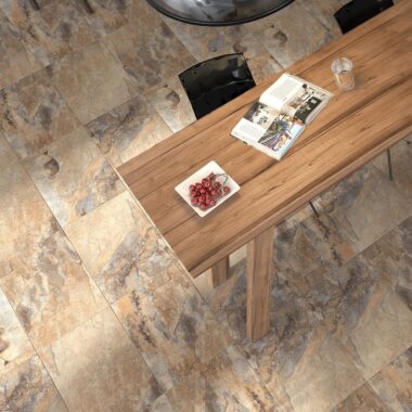 Keystone Brown Tiles - Stone Effect in a living room setting. Long wooden table with a brown chair.