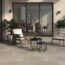 Taxos Light Grey Limestone Tiles in a patio setting. French windows in the background and patio furniture.