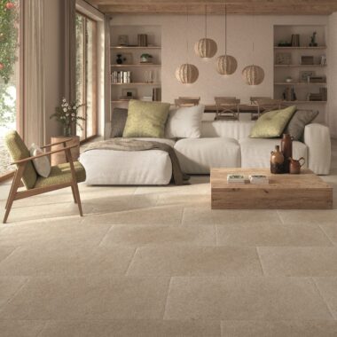 Taxos Sand Limestone Effect Tiles in a lovely calm beige living room. L shaped sofa and easy chair.